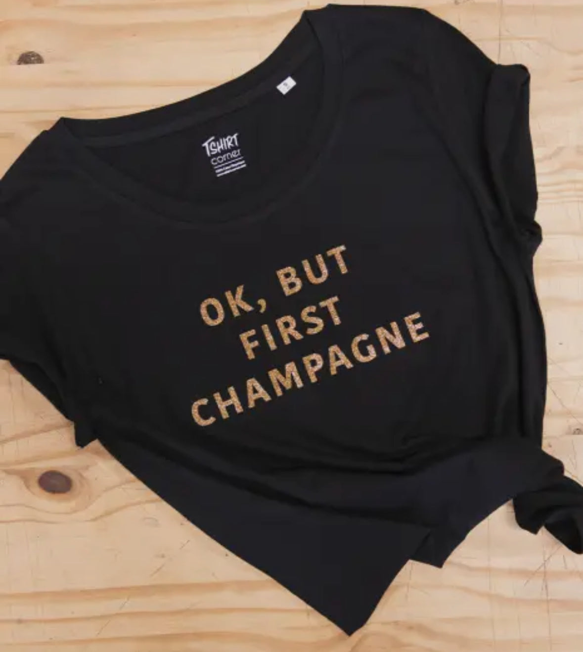 Svart t shirt med guldglittrig text.
Ok, but first champagne 