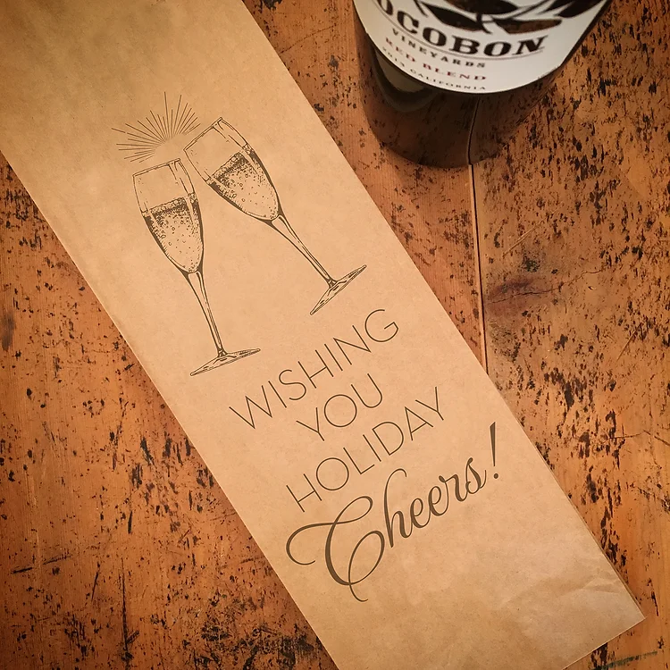 Vinpåse i papper med jultema och texten "wishing you holiday cheers"